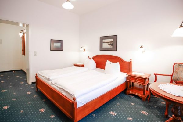 Bett im Doppelzimmer mit Balkon vom Hotel Stranddistel in Göhren auf der Insel Rügen
