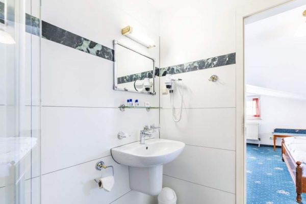 Bathroom of the attic-style double room at Hotel Stranddistel – accommodation with balcony in Goehren, Ruegen Island