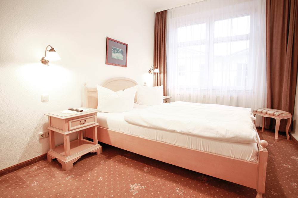 Schlafzimmer der Suite mit Balkon im Hotel Stranddistel im Ostseebad Göhren auf Rügen