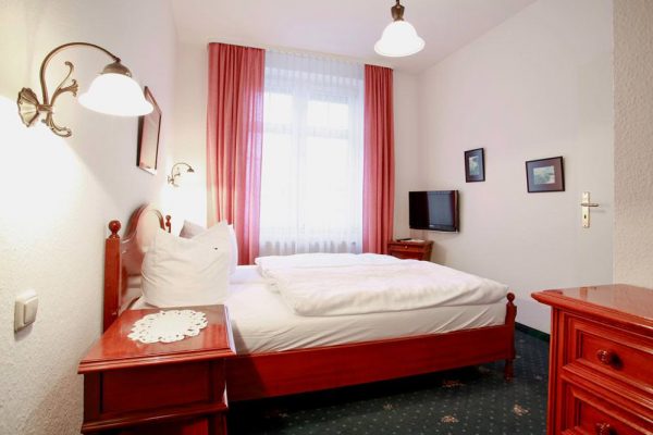 Bett der Suite mit Balkon im Hotel Stranddistel im Ostseebad Göhren auf Rügen