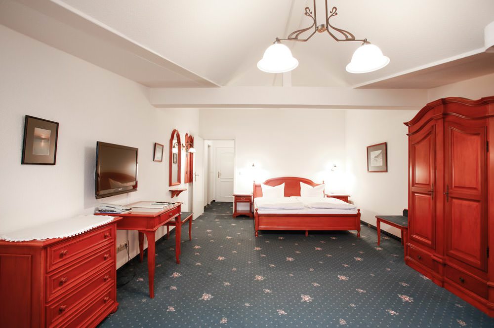 Schlafzimmer der Juniorsuite mit Balkon im Hotel Stranddistel in Göhren auf der Insel Rügen