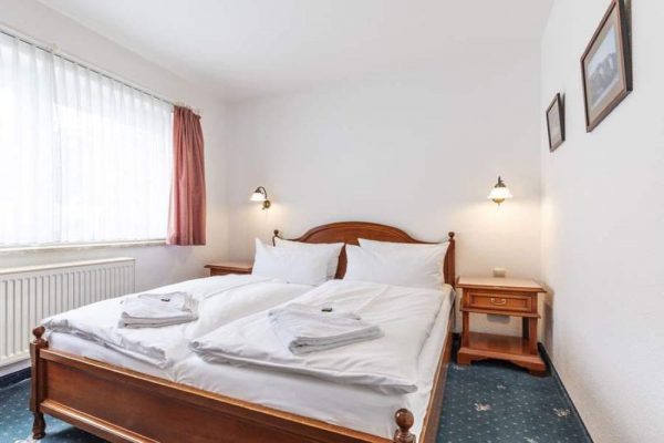 Bett für 2 Personen im Schlafzimmer der Suite vom Hotel Stranddistel im Ostseebad Göhren auf Rügen